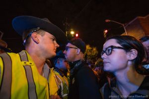Protesters stand off with Police Officers as they try to continue their stopped protest