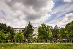 Protesters march along the Beltline past people riding bikes along it
