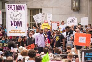 Reverand Raphael Warnock speaks to protesters using a microphone
