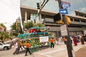 Festival Participants push a ornate cart with them as they continue the festival