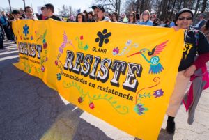 Protesters hold up a large banner calling for resistance