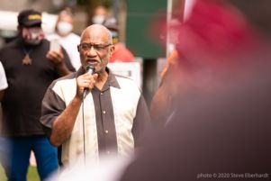 An older protester uses a microphone to speak to protesters