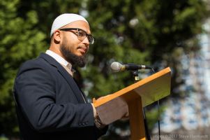 A protester stands at a podium giving a speech