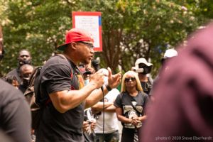 Family members of Rayshard Brooks speak to gathered protesters using a microphone