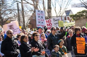 Protesters gather together holding signs to protest Trump's Immigration Policy