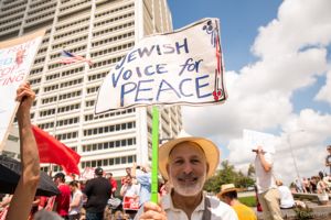 A protester holds up a sign reading 'Jewish Voice for Peace'