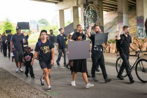 Protesters march underneath a bridge as they continue their protest