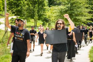 Protesters march along the Beltline with fits raised and taped over mouths