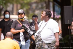 Two protesters use a bullhorn to speak to gathered protesters