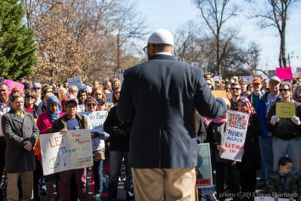 Protesters look on and listen as a protester gives a speech
