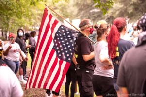 A protester holds up a upside down American flag