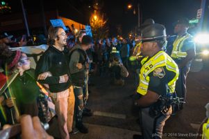 Protesters link arms as they stand off with Police Officers