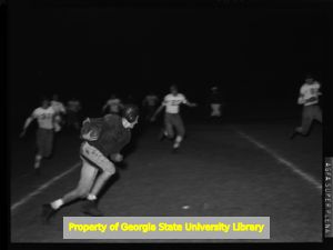 High School football player running a sweep play, Atlanta, Georgia, circa late 1930s or early 1940s