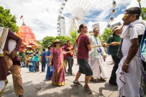 Participants hold onto a rope as they help move a chariot through the streets