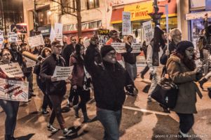 Protesters march through downtown Atlanta holding a glowing Black Lives Matter sign