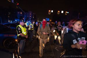 Protesters continue on their march past police officers blocking off other routes for their protest