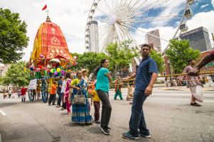 Participants hold onto a rope as they help move a chariot through the streets