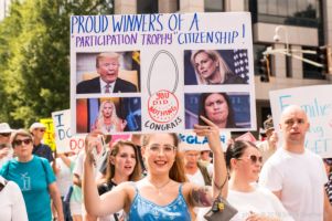 A protester holds up a sign awarding ""Participation Trophies' to leaders who 'did nothing'