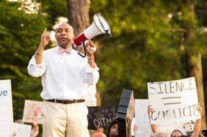 Mawuli Davis uses a bullhorn to give a speech to fellow protesters