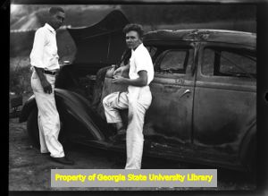 Mechanics working on a burned out car, Atlanta, Georgia, circa late 1930s or early 1940s