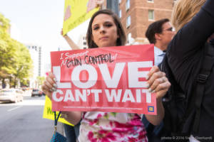 Protester with sign "I support gun control! Love can't wait."