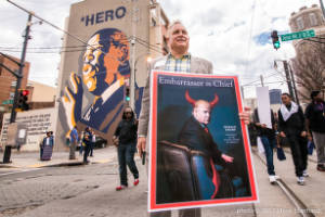 Jackson Faw stands with sign, "Embarrasser in Chief";