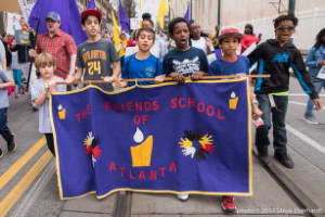 Children walk with sign, "The Friends School of Atlanta"