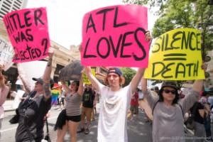 Protesters hold signs, including "ATL loves" and "Silence = Death"