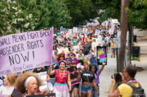 Protesters march with signs, including "Stonewall Means Fight Back! Transgender Rights Now!"