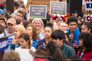 A woman holds a sign that reads, "Guns have more rights than my vagina"