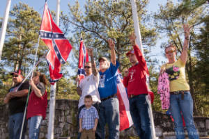Protesters hold Confederate flags and perform a Ku Klux Klan salute