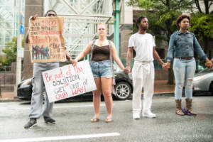 Protesters hold hands and signs in the street