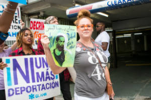 Protesters walk with signs, including "We Will Defend Each Other"