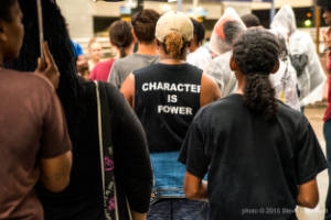 A protester wears a shirt that reads, "Character is power'