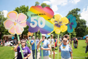 Protesters hold signs painted like pansies