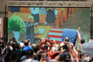 President Barack Obama is seen on a large outdoor video screen