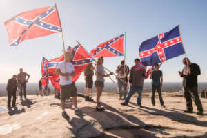 Protesters stand on top of Stone Mountain holding Confederate flags