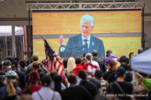 President Bill Clinton is seen on a large outdoor video screen