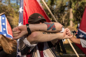 A man shows tatoos on his arms
