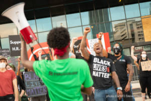 Protesters stand with raised fists outside of the CNN Center