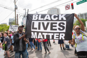 Protesters hold a "Black Lives Matter" banner in the intersection of 10th St. and Piedmont Ave.