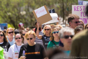 A protester carries a sign that reads, "Enough"