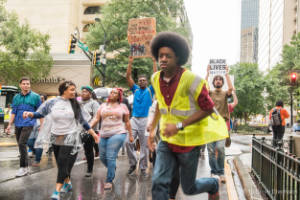 Protesters march in the street in the rain