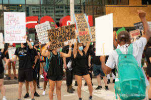 Protesters hold signs outside of CNN Center