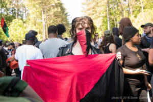A protester holds an anarchist flag