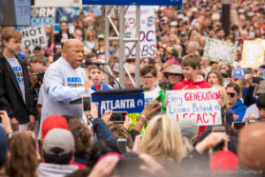 Congressman John Lewis stands next to students as he addresses the crowd