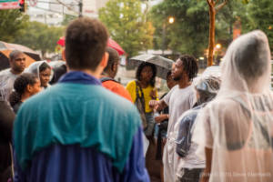 A man speaks to a group of protesters in the rain