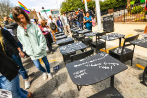 Black school desks are seen in a street with messages written in chaulk