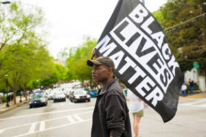 A protester carries a "Black Lives Matter" flag in the street
