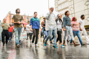 Protesters march through the street in the rain
